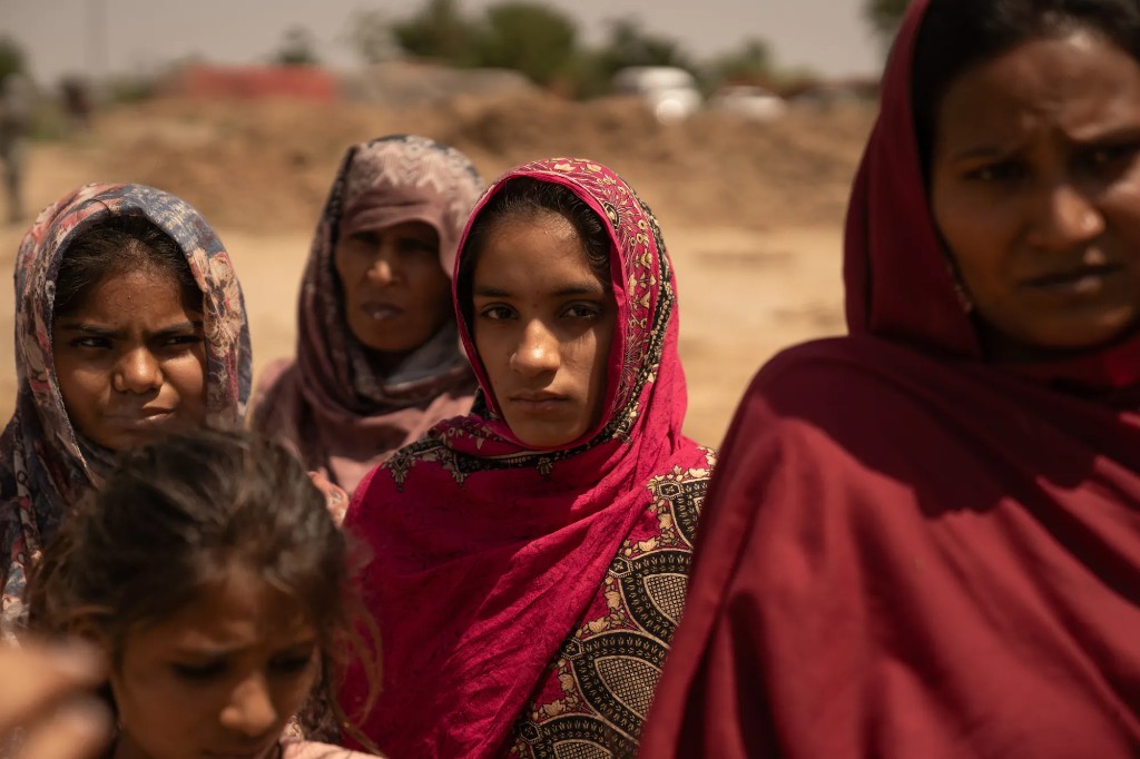 Women and girls in Pakistan standing together in a dusty outdoor setting
